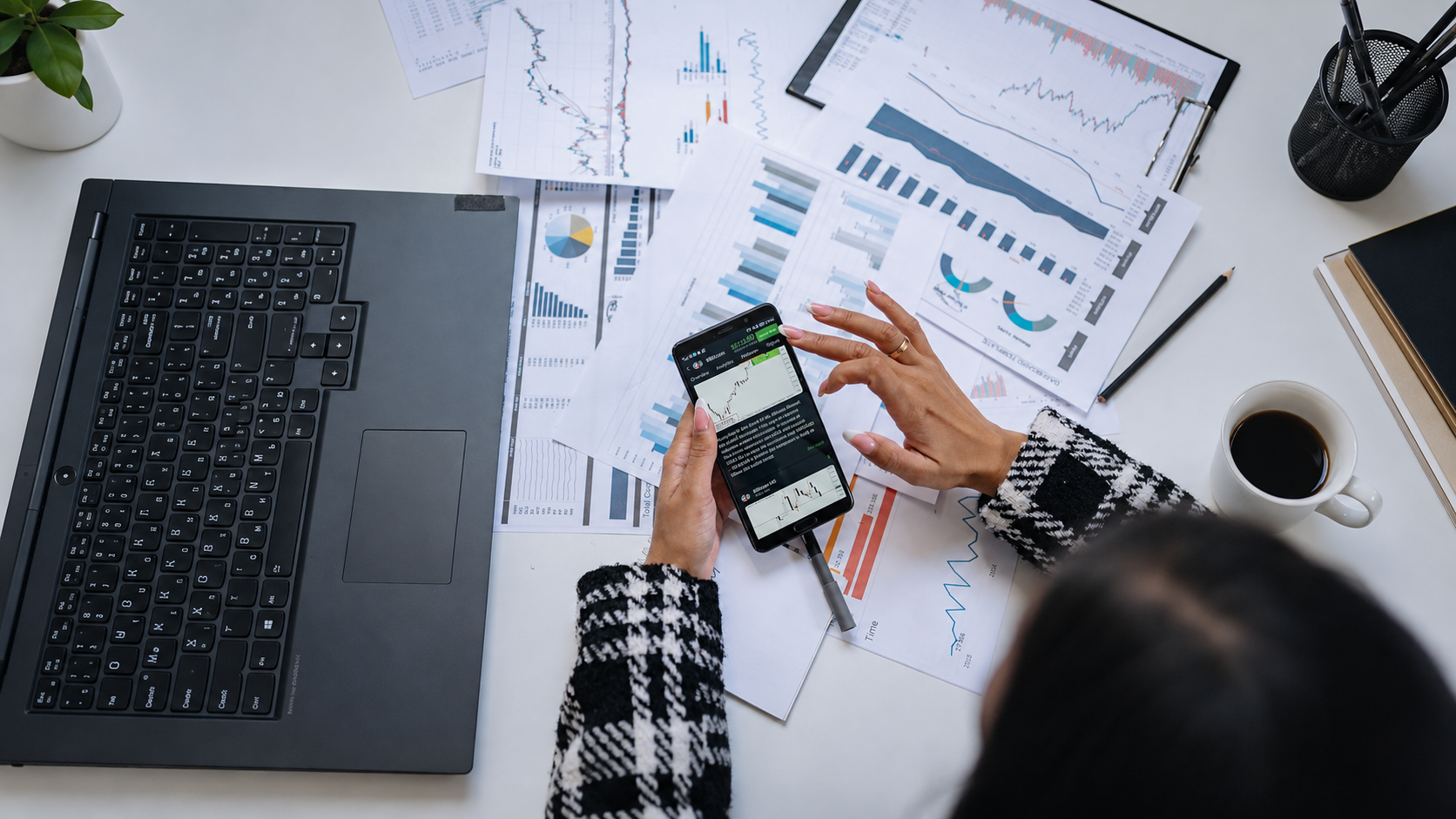 Printed financial charts and reports being reviewed at a desk